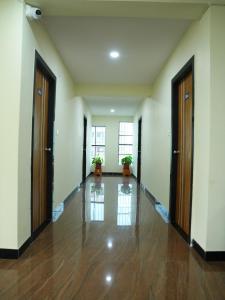 an empty hallway with two doors and wooden floors at Hotel Brinda in Kākināda +1 photo