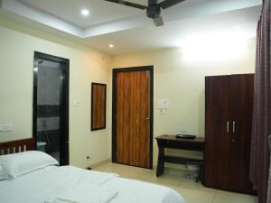a bedroom with a bed and a wooden door at Hotel Brinda in Kākināda