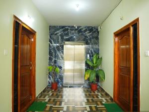 a hallway with a shower and two doors and plants at Hotel Brinda in Kākināda