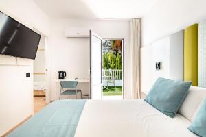 a bedroom with a white bed and a sliding glass door at Smart Hotel Cabo Sur in Mojácar