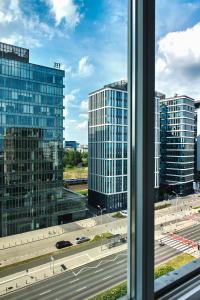 a view from a window of a city with tall buildings at Lumina I Spacious 3BR Apartment with Parking I Balcony I Warszawa Zachodnia in Warsaw