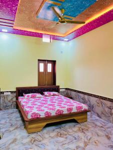 a bedroom with a bed with pink sheets and a ceiling at Chhagan Sharma in Phalodi