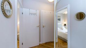 a bedroom with a white door and a mirror at Baltic Pine by Pino Resort in Gdańsk