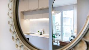a mirror reflection of a kitchen with a sink at Baltic Pine by Pino Resort in Gdańsk +25 photos