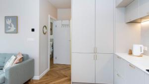 a kitchen and a living room with white cabinets at Baltic Pine by Pino Resort in Gdańsk