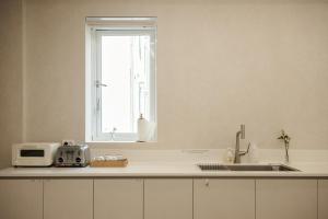a kitchen with a sink and a window at 쉼스테이 in Myŏnghag-yŏk +66 photos