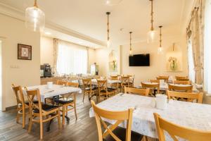 a restaurant with tables and chairs and a tv at Aquasol Resort in Mosonmagyaróvár