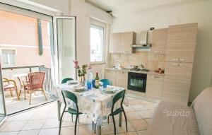 a kitchen with a table and chairs and a kitchen with a table and chairsktop at Residence Doral in Rimini
