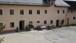 a large white building with a bench in the courtyard at Ferienwohnung Langhof in Schernfeld