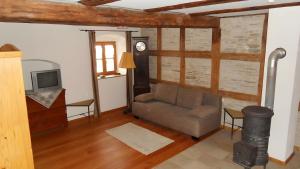 a living room with a couch and a tv at Ferienwohnung Langhof in Schernfeld