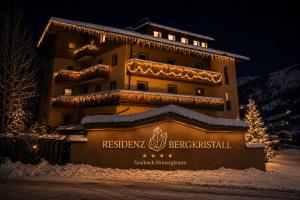 a building with christmas lights on it in the snow at Residenz Bergkristall in Saalbach-Hinterglemm