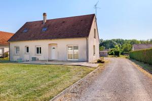a white house with a brown roof on a dirt road at Le Karush proche chambord in Mer