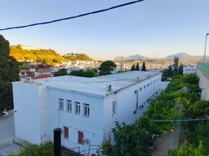 a white building on a street with mountains in the background at Sky-Line Apartments in Afantou