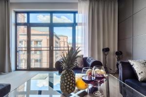 a living room with a pineapple on a glass table at Lumina I Comfy Loft with Parking I View of the Lake in Łódź