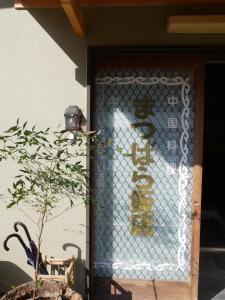 a door with a sign on the side of a building at ましこのま- 明治の建物をリノベした街中ローカルステイ in Mashiko