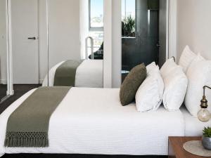 a bedroom with two beds with white pillows at Rise to the top! in Melbourne +51 photos
