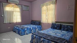 a room with two beds and two windows at 藍嶼休閒民宿 in Lanyu