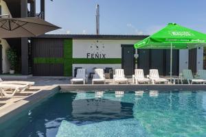 a swimming pool with chairs and a green umbrella at Fenix in Solotvyno