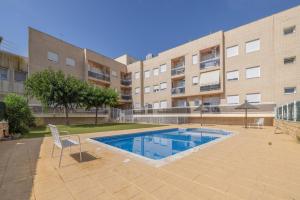 a swimming pool in front of a building at Planta baja Marita in Deltebre