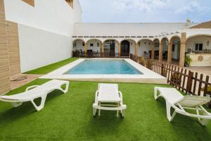 a pool with two lounge chairs and a swimming pool at El Llano in Sierra de Yeguas