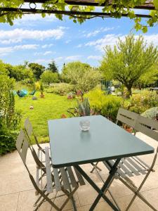 a table and chairs with a view of a garden at L'Oléastre en Luberon in Grambois