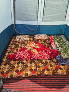 a group of fabrics on a bed in a tent at Gurez valley camping site in Gurais