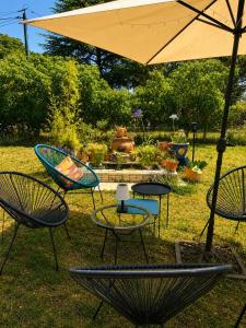 a group of chairs and an umbrella in a yard at L'Oléastre en Luberon in Grambois
