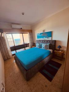 a bedroom with a large bed with a blue bedspread at Sofiamarholidays - Casa Praia Mar in Portimão