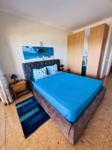a bedroom with a large bed with a blue mattress at Sofiamarholidays - Casa Praia Mar in Portimão
