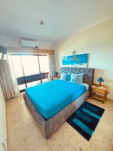 a bedroom with a large bed with a blue bedspread at Sofiamarholidays - Casa Praia Mar in Portimão