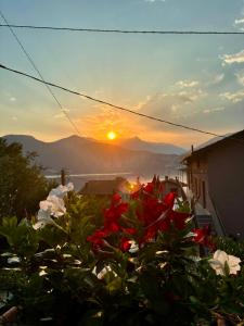 a view of the sunset from a garden with flowers at La Casa sulla Roccia in Pisogne