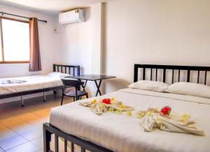 a hotel room with two beds with flowers on them at Patong Canal Villa 208 in Patong Beach