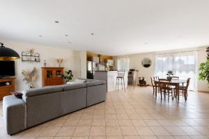 a living room and kitchen with a couch and a table at Le Refuge des deux Cœurs - Beauval in Villefranche-Sur-Cher