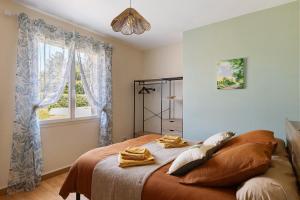 a bedroom with a bed with towels on it at Le Refuge des deux Cœurs - Beauval in Villefranche-Sur-Cher