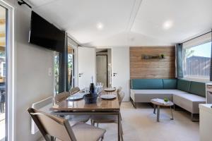 a living room with a table and a couch at Mobilehome Evasion 55 in Saint-Gervais