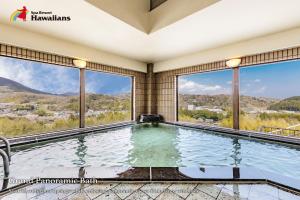 a swimming pool with a view of the mountains at Spa Resort Hawaiians Hotel Hawaiians in Iwaki