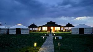 a person standing in front of a group of tents at Gobi Sun Lodge in Hushuu Hural +40 photos