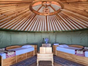 a room with two beds in a roofed room at Gobi Sun Lodge in Hushuu Hural