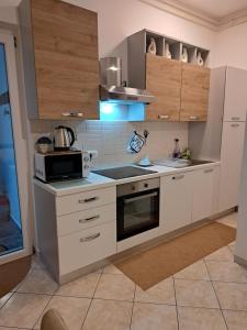 a kitchen with white cabinets and a microwave at Dorea in Jagodje