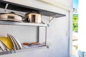 a kitchen with plates and pans on a shelf at Patong Canal Villa 208 in Patong Beach +11 photos