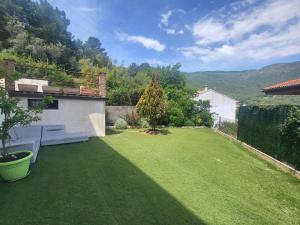 a backyard with a grass yard with a bench at Bellavista in Piedralaves