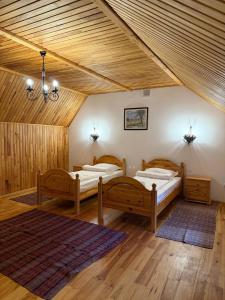 two beds in a room with wooden ceilings at Плай in Khmelnytskyi