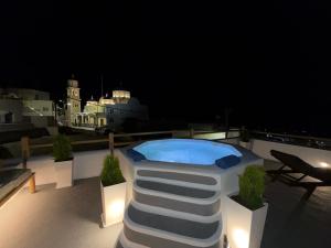 a swimming pool on the roof of a building at night at Dimael Mansion in Fira