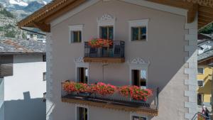 a building with two balconies with flowers on it at Maison Luboz - Courmayeur in Courmayeur