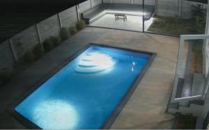 an overhead view of a large blue swimming pool at Sunset Villa in Mysore +2 photos