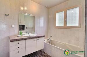 a bathroom with a sink and a tub and a mirror at Ar gwelva in Cléguérec +37 photos