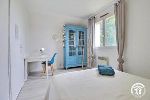a bedroom with a bed and a desk and a blue door at Ar gwelva in Cléguérec