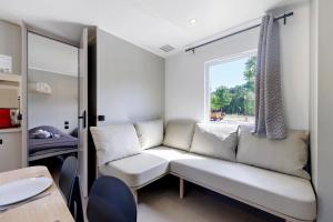 a living room with a couch and a window at Mobilehome Vallon 57 in Saint-Gervais