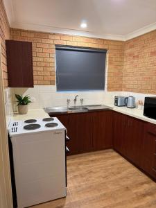 a kitchen with a white stove and a sink at Corner unit in Geraldton in Geraldton +3 photos