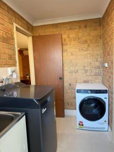 a washer and dryer in a kitchen with a sink at Corner unit in Geraldton in Geraldton